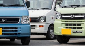 Close-up of a Honda Acty, Suzuki Carry, and Daihatsu Hijet parked in a row.